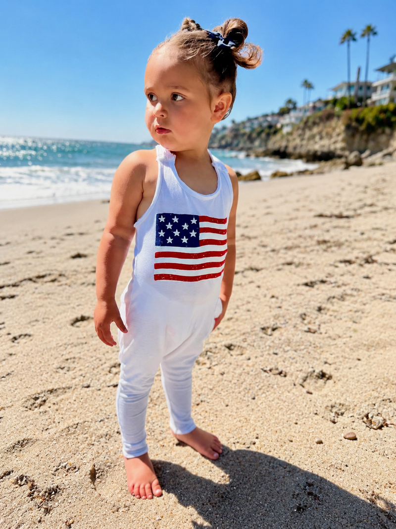 child wearing Be Mi Americana romper on the beach