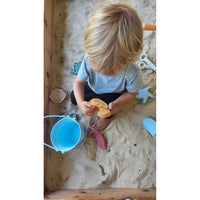 Silicone sand toy bucket with colorful toys and shovel for children, perfect for beach or sandbox play.