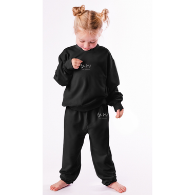 Child wearing a black outfit with branding on a white background