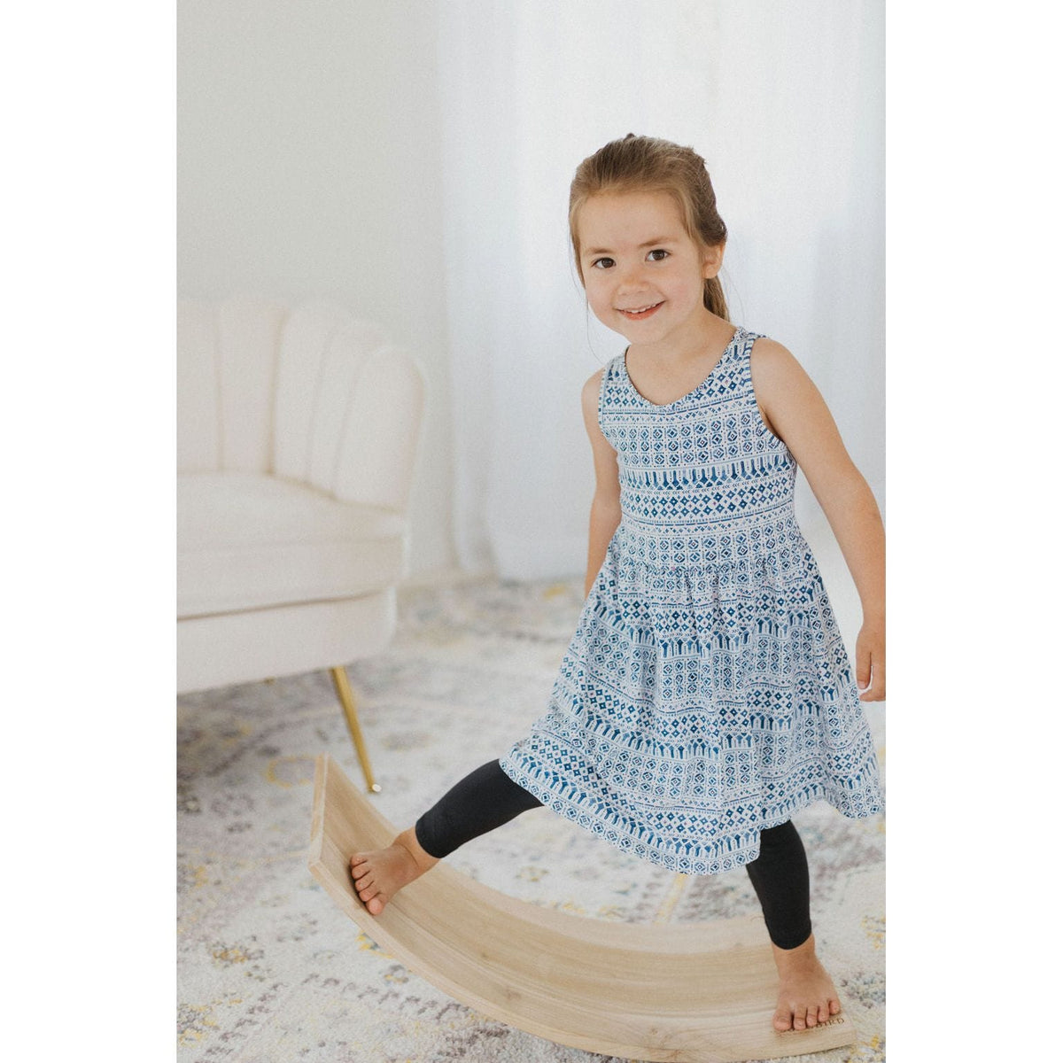 Child balancing on a ShopMyLittleSongbird balance board toy, showcasing its curved rocker design for fun and active play.