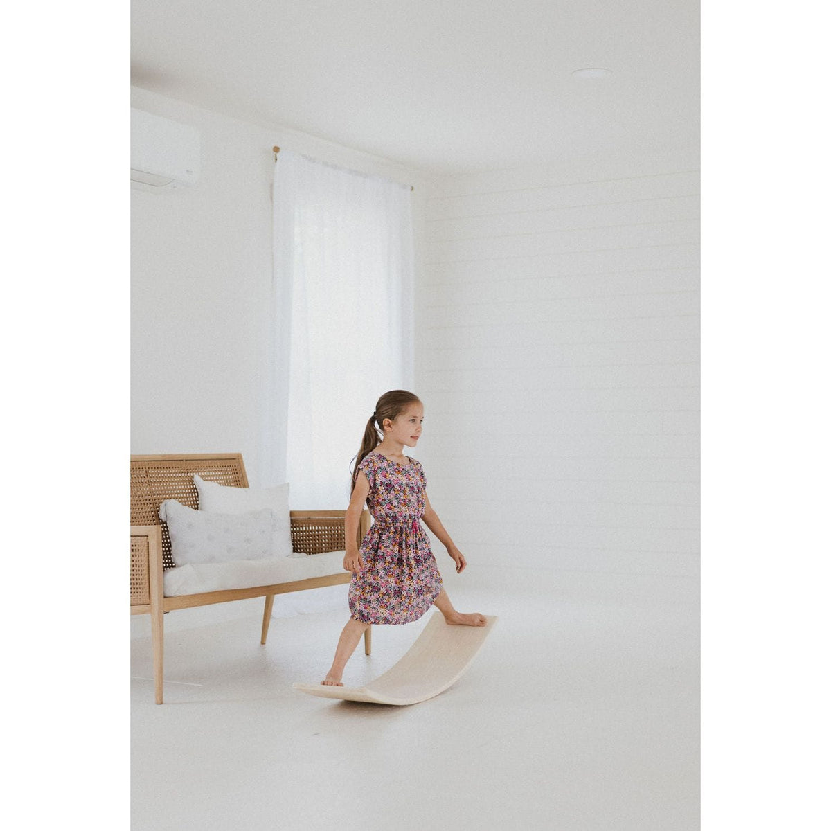 Child balancing on a ShopMyLittleSongbird balance board toy, designed for stability and fun indoor play.
