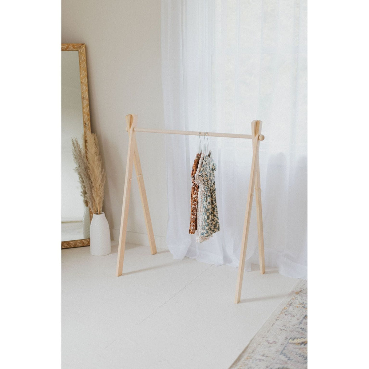 Wooden toddler clothes rack from ShopMyLittleSongbird, featuring a sturdy wooden frame and hooks for hanging small clothes.