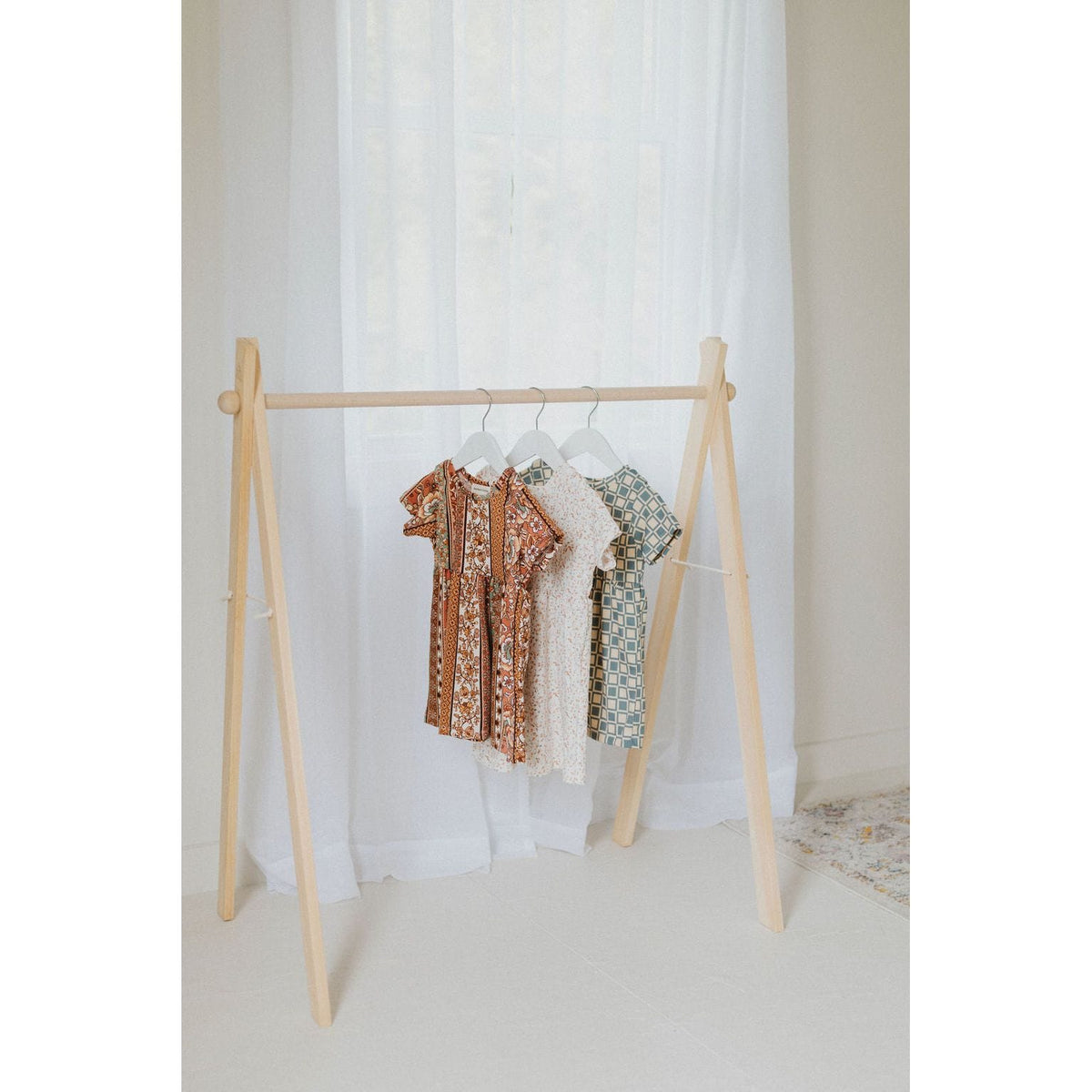 Wooden toddler clothes rack from ShopMyLittleSongbird, featuring a sturdy wooden frame and small hanging rods for children's clothing.