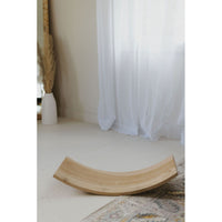 Child balancing on a ShopMyLittleSongbird balance board rocker, toy for active play and coordination.