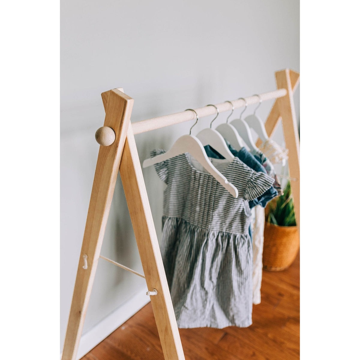 Wooden toddler clothes rack with hangers, part of ShopMyLittleSongbird's wooden toy collection, ideal for organizing children's clothing.