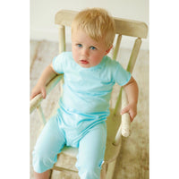 Be Mi Los Angeles pocket romper for boys, featuring a stylish design, displayed on a chair in the image.