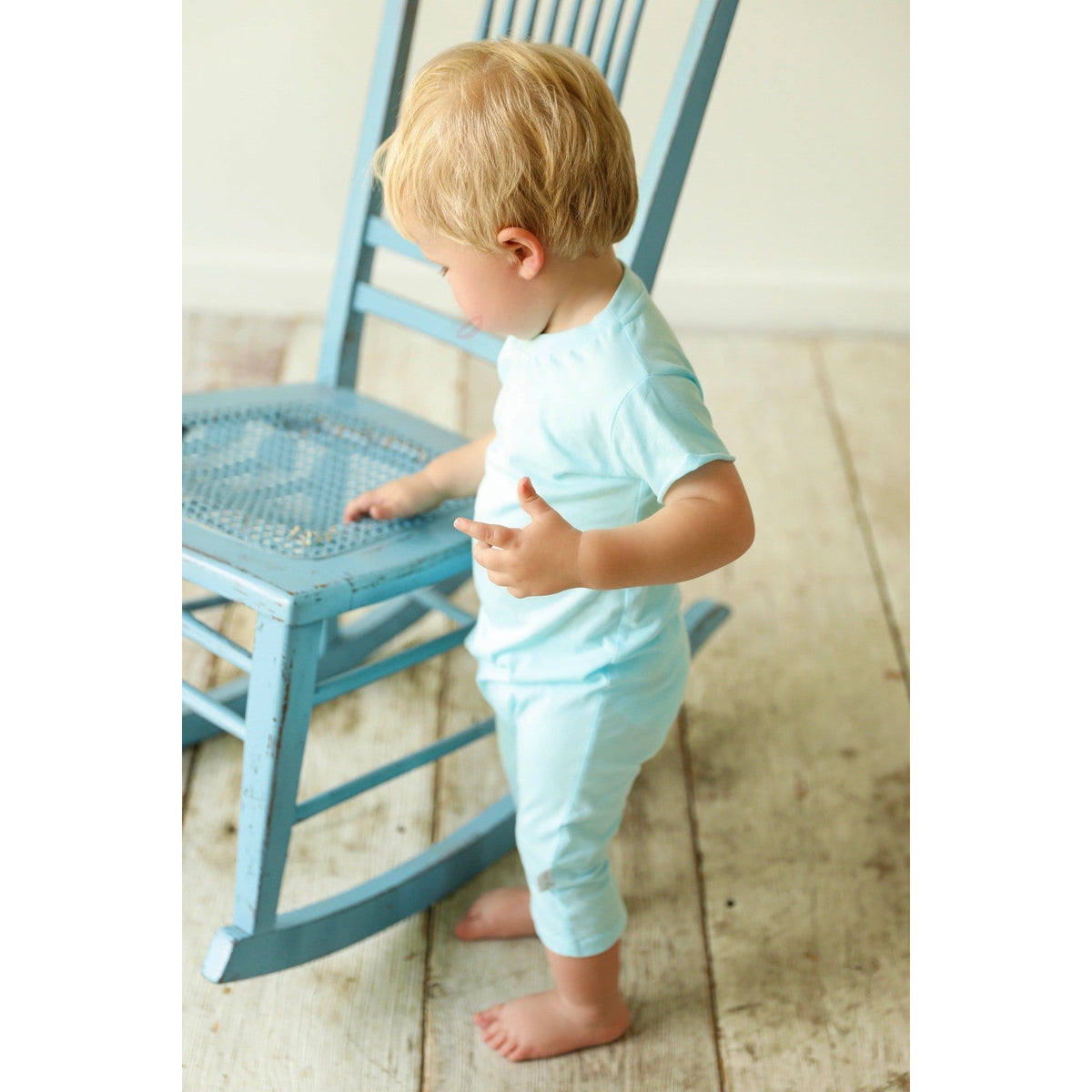 Boy wearing a be mi los angeles pocket romper with short sleeves and playful print, front view, casual summer outfit.