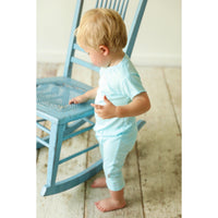 Boy wearing a be mi los angeles pocket romper with short sleeves and playful print, front view, casual summer outfit.