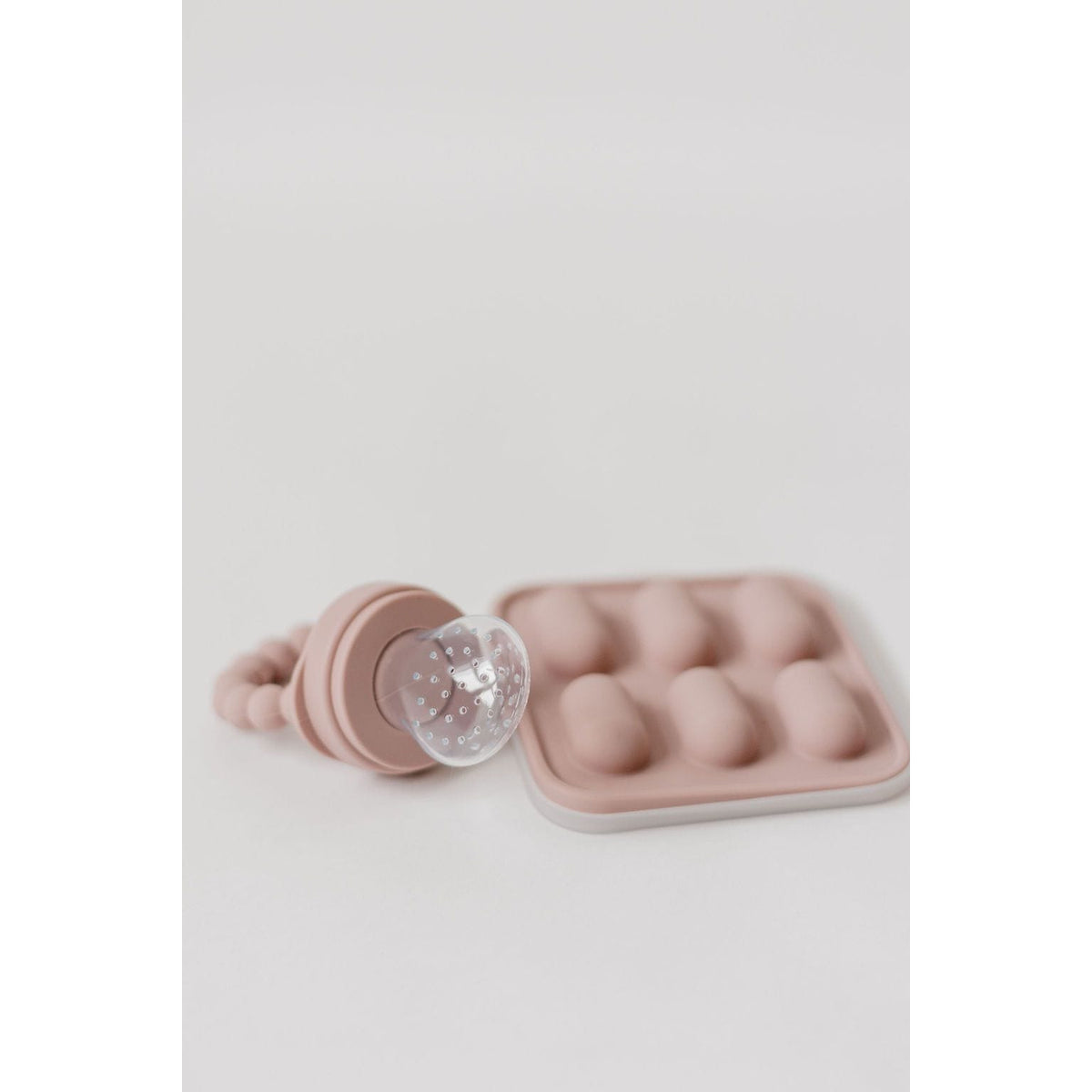 Silicone fruit feeder and ice tray set with colorful silicone inserts for baby feeding and ice making, bright and flexible in design.