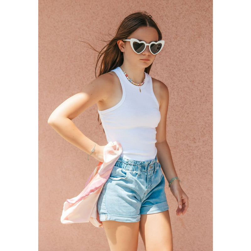 girl wearing whiterib tank top white sunglasses and jean shorts