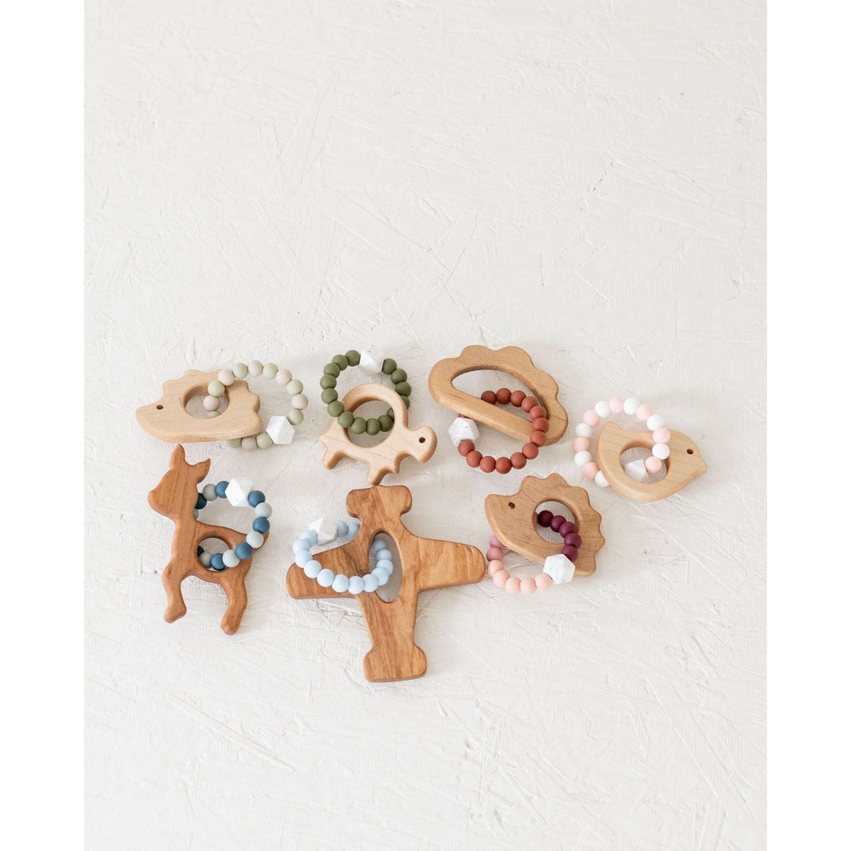 Wooden teether with silicone ring for babies, natural wood and colorful silicone, designed for soothing teething discomfort.