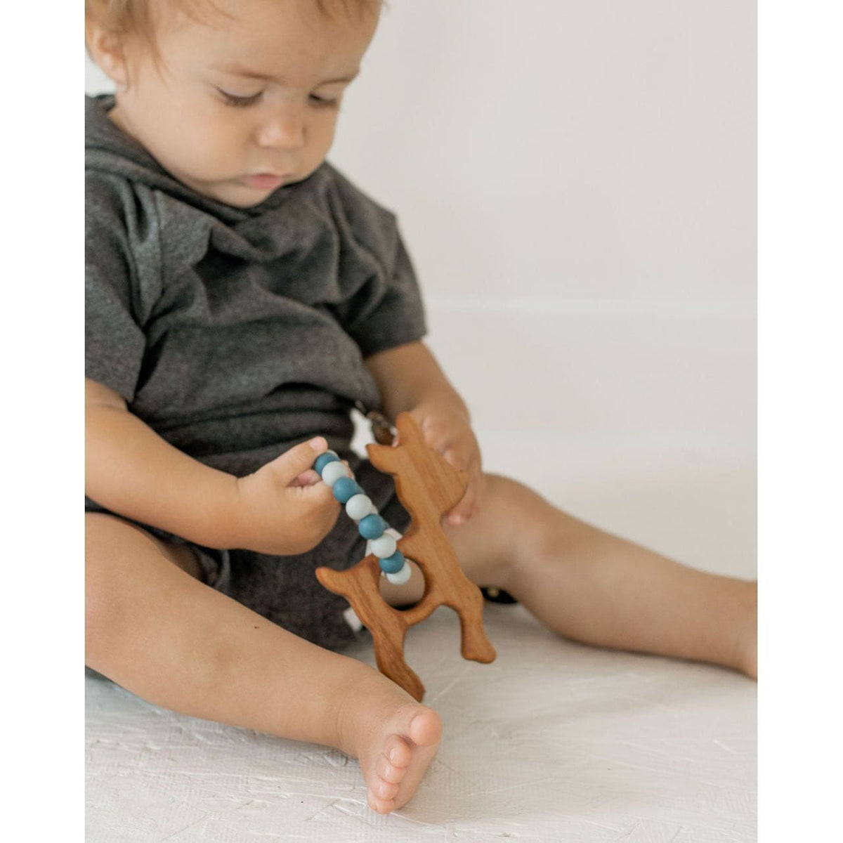 Wooden teether with silicone ring for babies, natural and safe teething toy from ShopMyLittleSongbird, shown with smooth wooden and silicone parts.