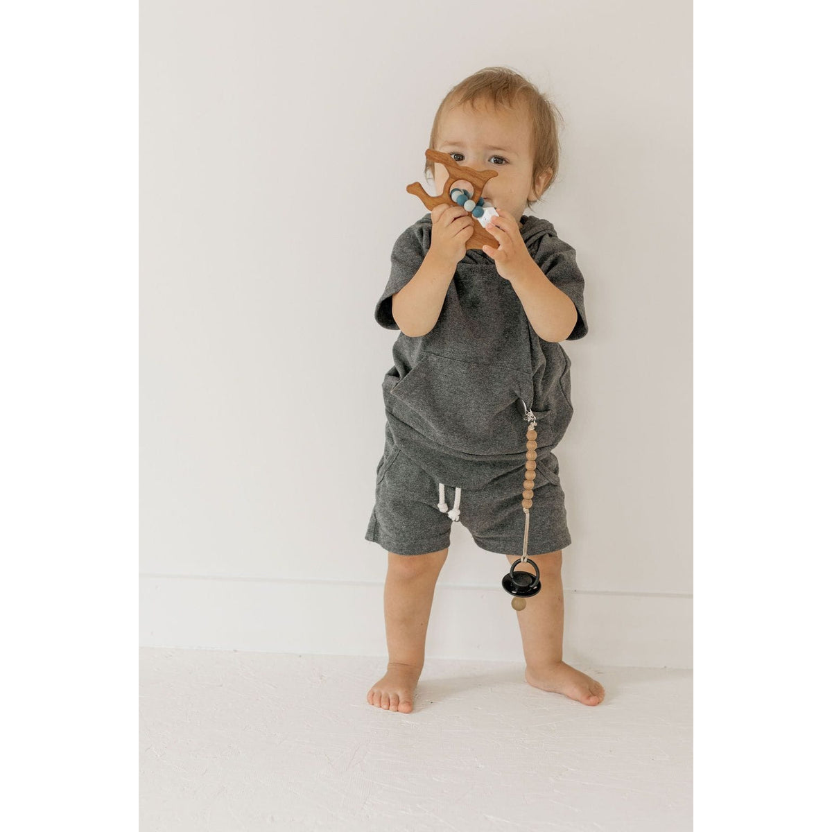 Wooden teether with silicone ring for babies, natural wood and soft silicone, perfect for soothing gums and teething relief.