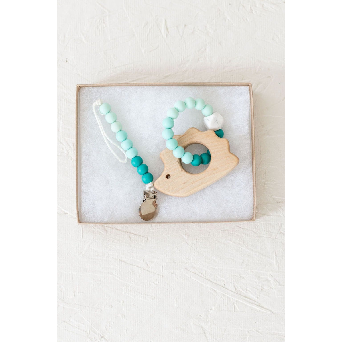 Wooden teether with silicone ring for babies, natural wood and colorful silicone, safe teething toy for infants.