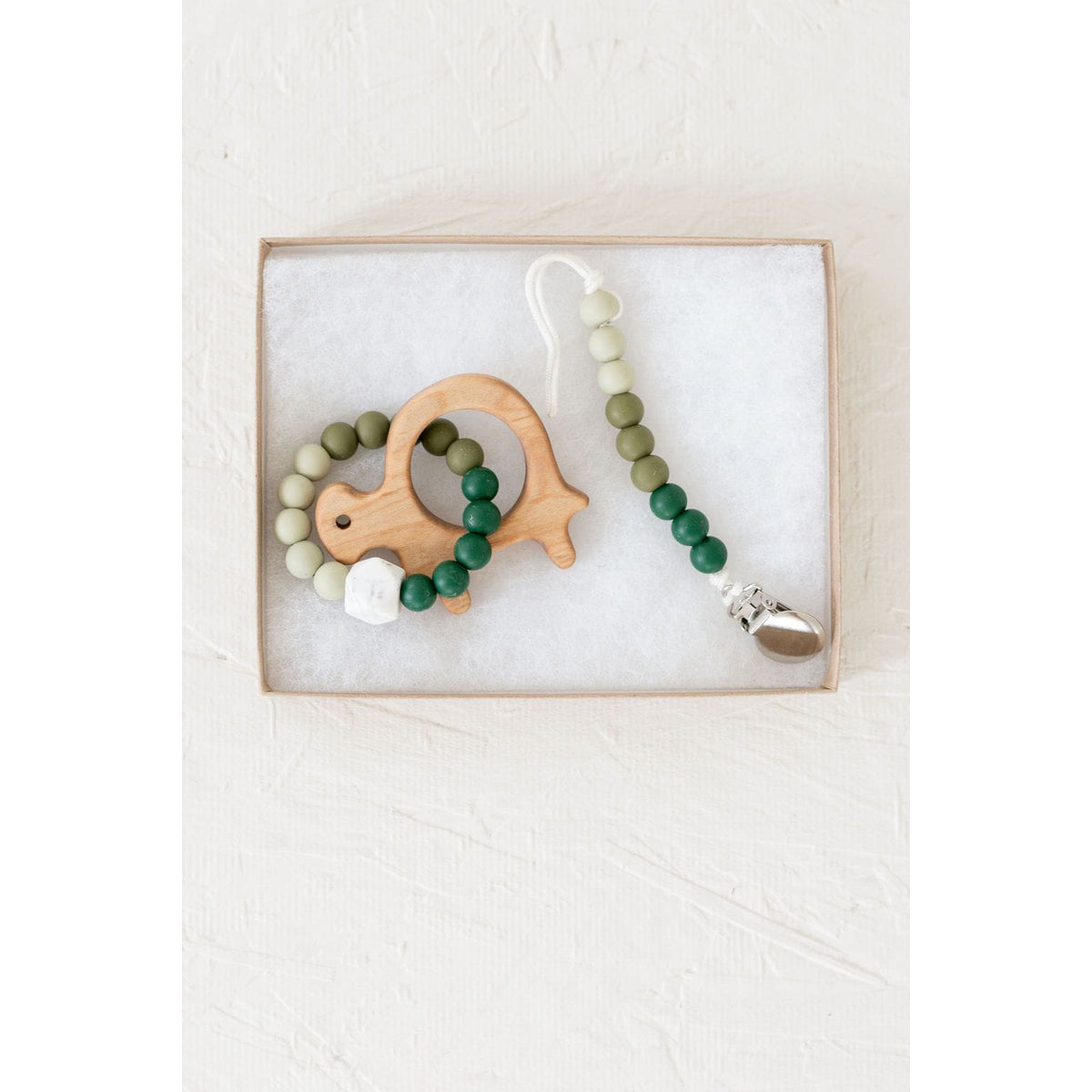 Wooden teether with silicone ring for infants, featuring smooth wood and colorful silicone, designed for teething relief.