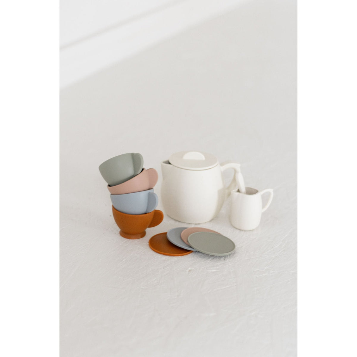Colorful silicone tea set toy with cups, teapot, and utensils for children, designed for imaginative play.