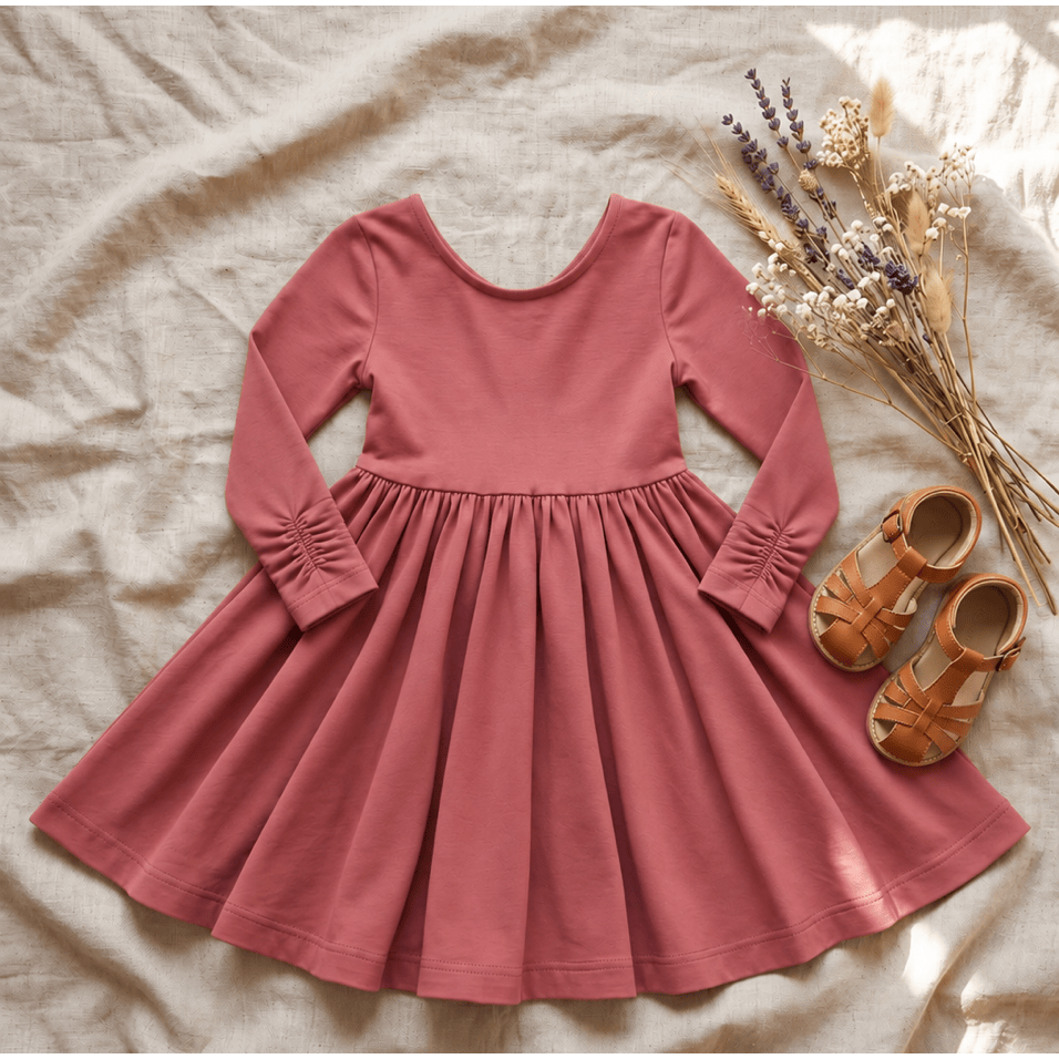  the Nova organic cotton twirl dress in muted berry, featuring a full circle skirt, round neckline, and delicate ruched sleeves.