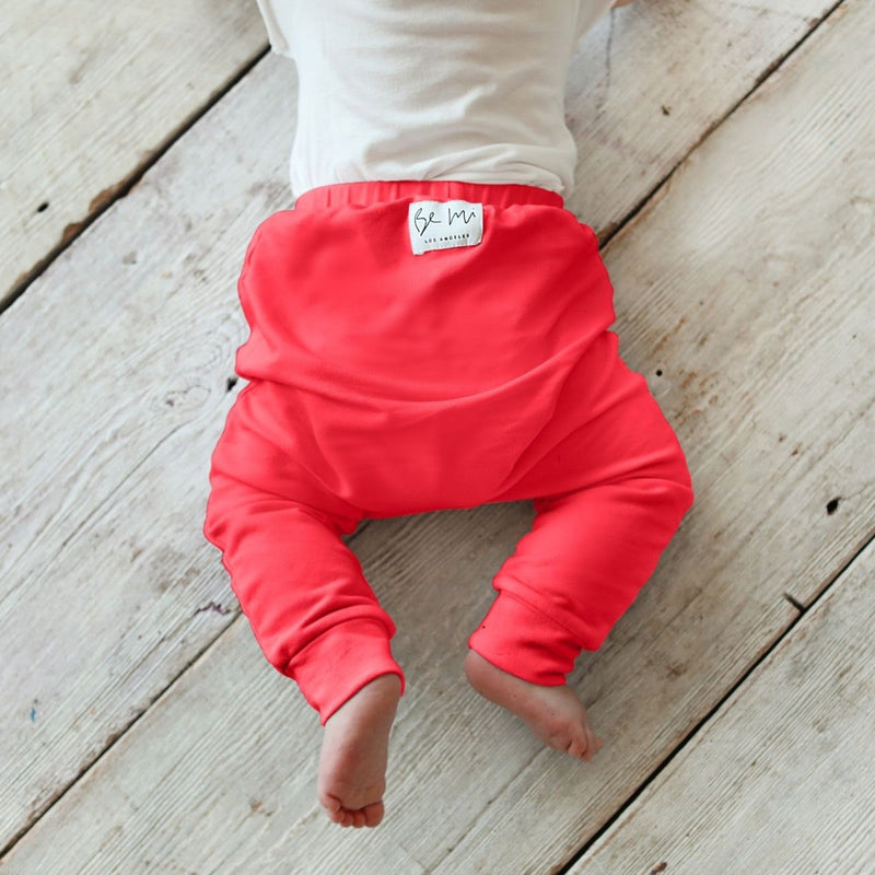 Red baby pants on a wooden floor