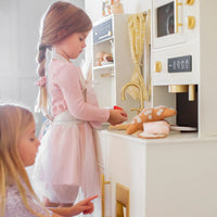 Tiny Land Inc. iconic wooden play kitchen in cream with pretend cooking accessories for kids, featuring realistic stove and countertop.