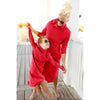 mom and daughter wearing red hooded dresses on a wooden deck.