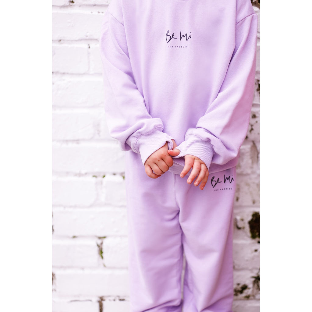 Two children wearing matching organic pink and lavender pajamas on a white background