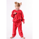 Child wearing a red outfit with a logo on a white background