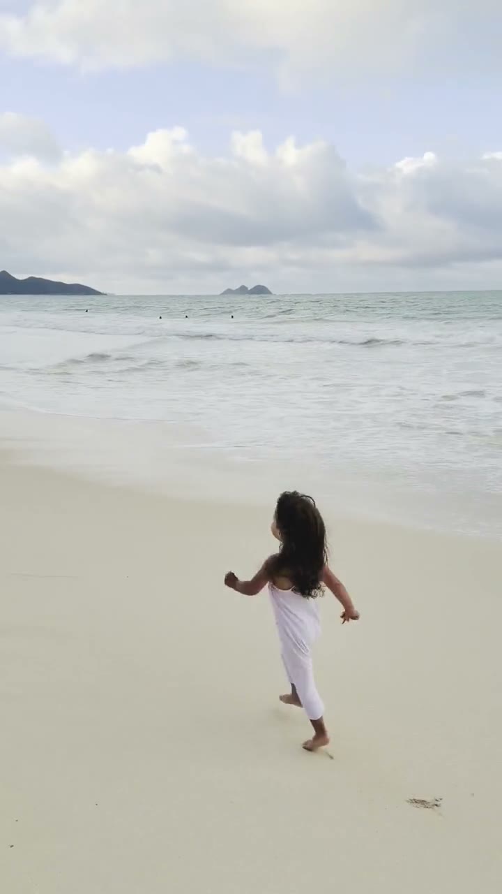 Girl in white romper running on the beach - video cover