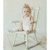 baby girl wearing cream organic pants and cotton soft pink tank top