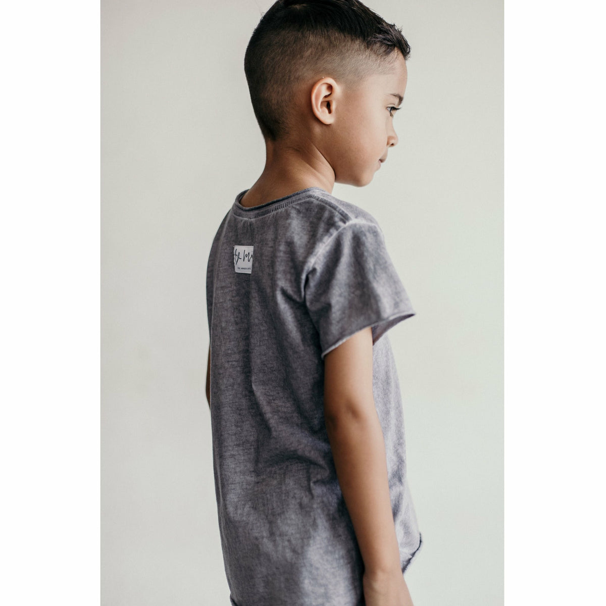 Be Mi Los Angeles Raw Edge Tee displayed on a hanger, showcasing its casual style and raw-edge design.