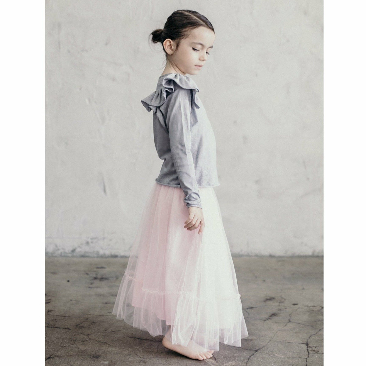 Be Mi Los Angeles Natalia Ruffle Top, stylish women's top with ruffle details, displayed on a hanger.
