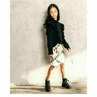 Black organic Victoria ruffle sleeve top by Be Mi Los Angeles, showcasing its stylish ruffled sleeves and soft fabric.