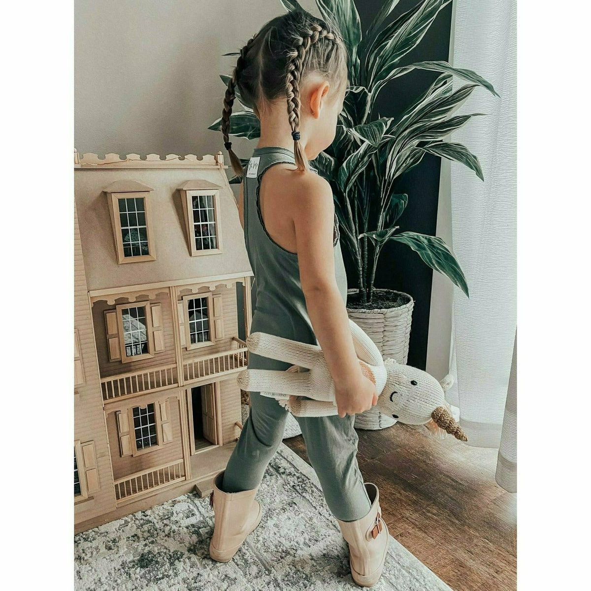 Olive-colored Be Mi Los Angeles romper with short sleeves and relaxed fit, displayed on a hanger against a plain background.