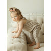 baby girl wearing cotton tan color romper plays