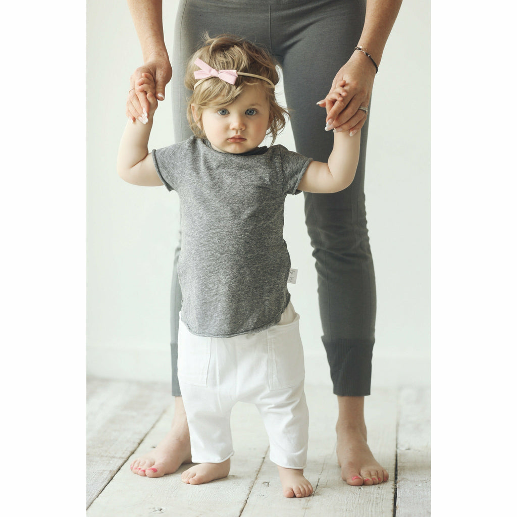 baby girl wearing heather grey t-shirt and white cotton shorts soft